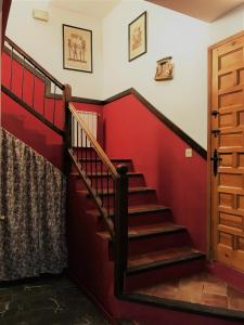 Los MolinosCasa Rural La Escuela的一座有红色墙壁的房子里的楼梯