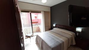 阿利坎特Alicante & Urban Center的一间卧室设有一张床、一台电视和一个窗口。