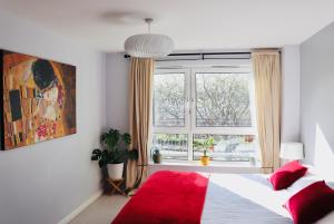 爱丁堡Luxflat - Port Of Leith - Free Parking的一间卧室设有红色的床和窗户。