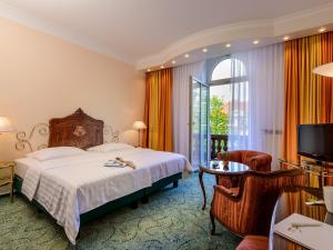 美因河畔法兰克福帕尔门霍夫酒店的一间卧室配有一张床、一张桌子和一台电视。
