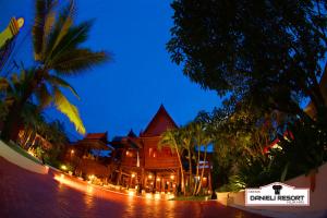 华欣达涅利度假村的度假村,在晚上有棕榈树的建筑