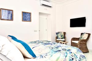 波西塔诺Gema Suites的一间卧室配有一张床和两把椅子