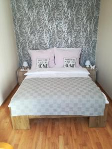 辛安诺泽蒂Manta Apartamenty的一间卧室配有一张带两个枕头和一面墙的床。