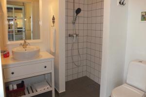Skovlund潘修来亚克力的一间带水槽和淋浴的浴室