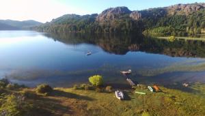 Lago FutalaufquenLaguna Larga Lodge的享有湖面上海岸上的船只景色