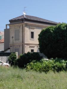 佩斯卡拉Dimora Dei Cento的前面有一棵树的老房子