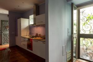 那不勒斯Aristovascio的厨房配有白色橱柜和窗户。