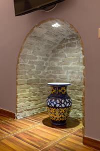 那不勒斯Aristovascio的砖墙旁边的地板上的花瓶
