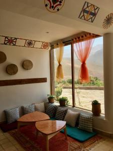 Zawyat OulmziTouda Ecolodge Atlas Mountains的带沙发和大窗户的客厅