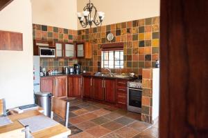 RietfonteinMilorho Lodge的厨房配有木制橱柜和墙上的瓷砖
