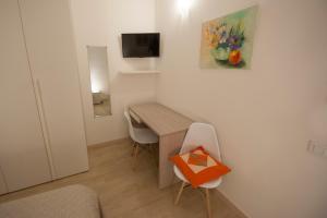 罗维戈ALL'ANTICO CAMPANILE的小房间设有书桌和桌椅
