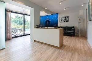 克里皮吉EOS Luxury Suites的客厅设有大电视和白色的台面