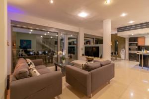 梅松吉Ionian Pearl Luxury Spa Villa的一个带两张沙发的大客厅和一间厨房