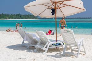迪弗西拉树西亚酒店的海滩上的一组椅子和一把遮阳伞
