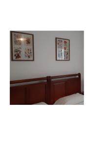 桑托尼亚Pensión CASA LEÓN的卧室配有两张床,墙上挂有两张照片