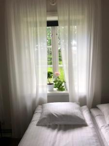 斯塔德Gårdshotellet的一间卧室配有床和白色窗帘的窗户