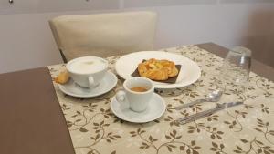 梅萨涅B&B Il Viandante的一张桌子,上面放着两杯咖啡和糕点