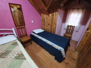 PainelPousada Canto de Pássaros的一间小卧室,配有一张床和两把椅子