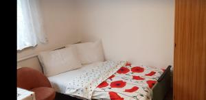 埃尔布隆格POKÓJ POMORSKA的小卧室配有红色鲜花的床