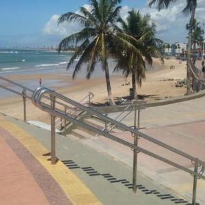 萨尔瓦多Kitnets com AR Condicionado na Praia的棕榈树和金属扶手的海滩
