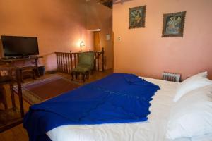 卡哈马卡普鲁亚旅馆的一间卧室配有一张带蓝色毯子的床