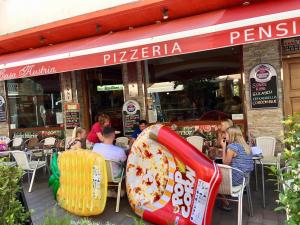 卡里拉卡萨奥斯特里亚膳食公寓的一群人坐在比萨饼店外面