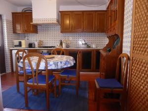 米尔芳提斯城CASA BERIMBAU的一个带桌椅的厨房和一间带木制橱柜的厨房
