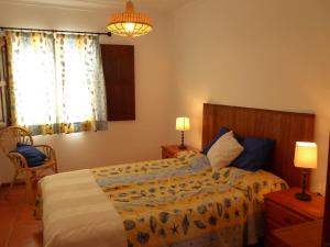 米尔芳提斯城CASA BERIMBAU的一间卧室配有一张床、两盏灯和一个窗户。