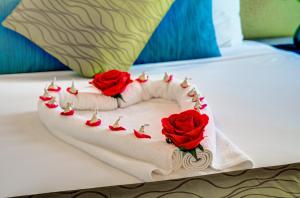 奥克兰VR奥克兰市度假酒店的床上的蛋糕,有三朵玫瑰
