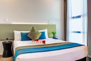 奥克兰VR奥克兰市度假酒店的一间卧室配有一张带鲜花的大床