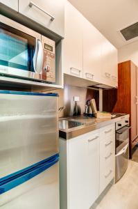 奥克兰VR奥克兰市度假酒店的厨房配有白色橱柜和不锈钢冰箱