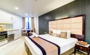 奥克兰VR皇后街套房酒店的一间带大床的卧室和一间厨房