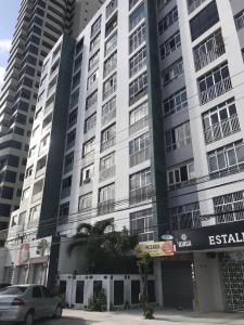 福塔莱萨Apartamento Fortaleza - Beira Mar - Mucuripe的一座高大的建筑,前面有一辆汽车
