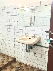 巴东Lestari Guesthouse的白色的浴室设有水槽和镜子