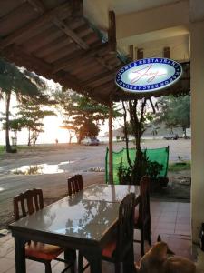 卡伦海滩托尼之家和餐厅旅馆的露台的遮阳伞下的桌椅