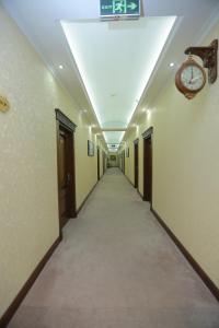 塔什干Hayot Hotel的墙上有时钟的长走廊
