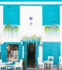 伊斯坦布尔热情实惠奥塔克依酒店的一座设有蓝色门和桌椅的建筑