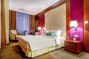 土龙木市Becamex Hotel New City的一间卧室设有一张大床和紫色的墙壁