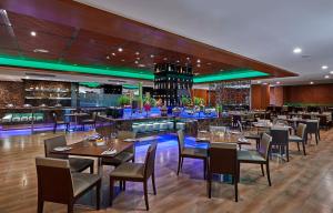 吉隆坡Swiss-Garden Hotel Bukit Bintang Kuala Lumpur的一间带桌椅的餐厅和一间酒吧