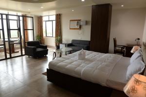 迪马普尔Hotel Lake Shilloi的一间带大床的卧室和一间客厅