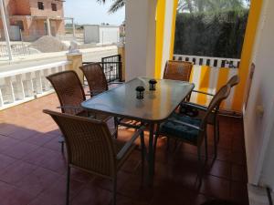 拉马丽娜Luxury and comfort in La Marina, with sea views at El Pinet beach的阳台配有桌椅、桌子和窗户