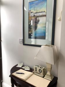 戈尔韦斯莱纳马拉住宿加早餐旅馆的一张桌子,上面有台灯和一张墙上的照片