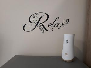 鲁塞Apartment RELAX的一张桌子,上面有花瓶和标志,上面写着放松