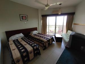 甘文丁Jana View Condotel MN的酒店客房,设有两张床和一张沙发