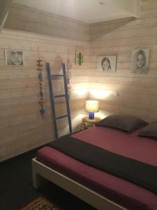 圣安尼雪兰朵别墅的卧室配有一张床,墙上挂着梯子和图片