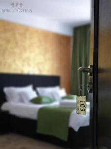 Căpăţîneni-PămînteniSpell Hotels的一间卧室配有带绿色和白色枕头的床