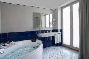 维耶特里劳埃德拜亚酒店的蓝色和白色的浴室设有浴缸和水槽