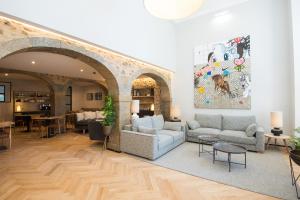 里斯本Urbano FLH Hotels Lisboa的客厅配有两张沙发,墙上挂有绘画作品