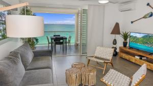 圣马丁岛Residence Bleu Marine - Honeymoon apartments的带沙发和电视的客厅,享有海景。