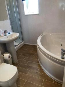 纽基Atlantic Lodge的浴室配有卫生间、浴缸和水槽。
